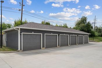 A building with a grey roof and grey garage doors at Aventura at Wentzville I & II Apartments, Missouri