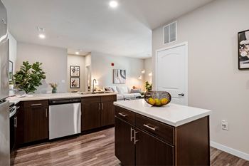 A kitchen with brown cabinets and a white countertop at Aventura at Wentzville I & II Apartments, Wentzville