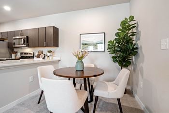 A modern kitchen with a dining table and chairs at Aventura at Wentzville I & II Apartments, Wentzville, MO