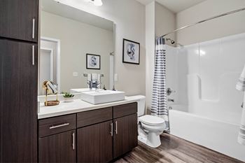 A bathroom with a white sink, toilet, and bathtub at Aventura at Wentzville I & II Apartments, Missouri, 63385
