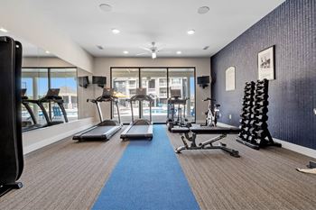 A gym with treadmills, weights, and exercise equipment at Aventura at Wentzville I & II Apartments, Wentzville, Missouri