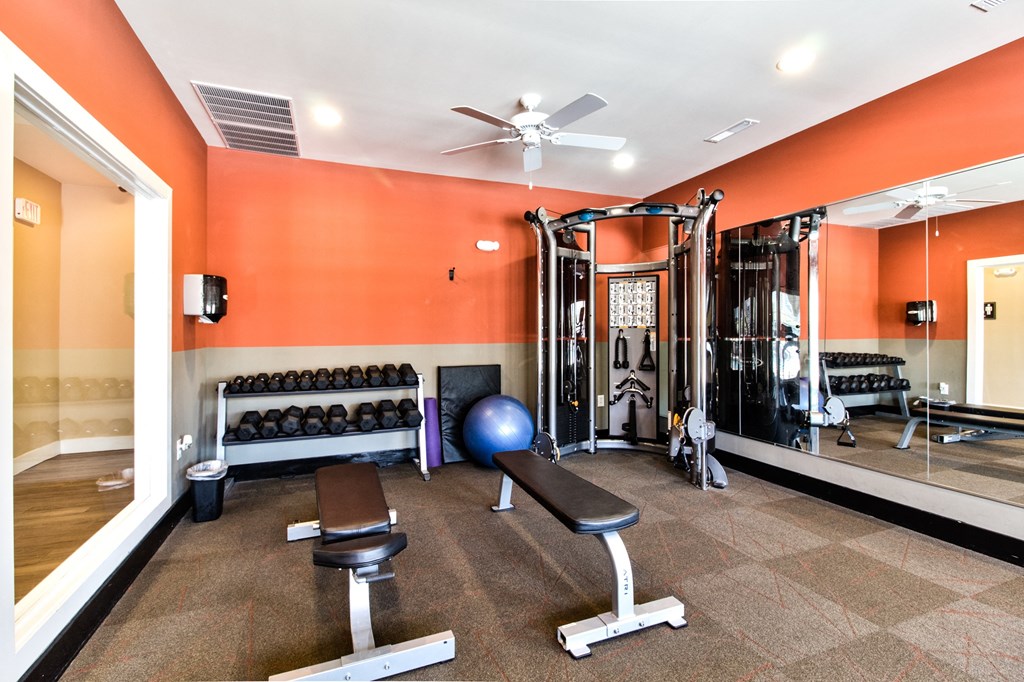 a gym with a lot of exercise equipment and a ceiling fan at Aventura at Richmond, St. Peters, 63376