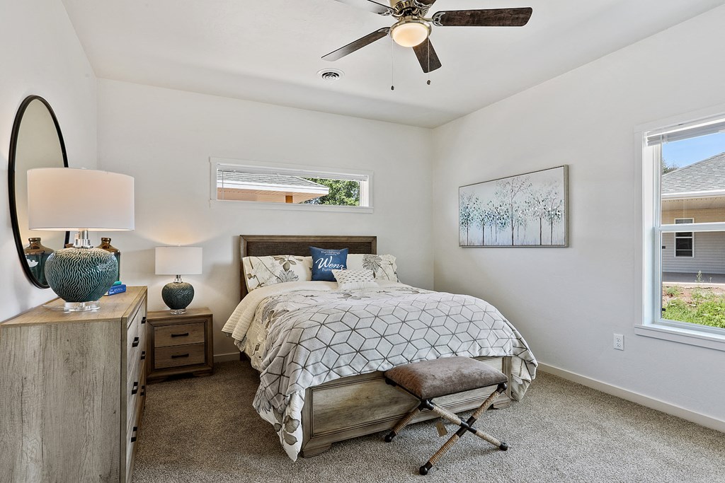a bedroom with a bed and a ceiling fan