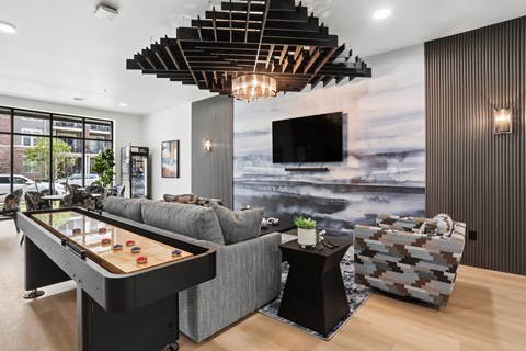 A modern living room with a pool table and a couch.
