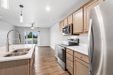A modern kitchen with wooden cabinets and stainless steel appliances.