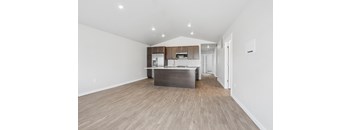A kitchen with wooden floors and white walls.