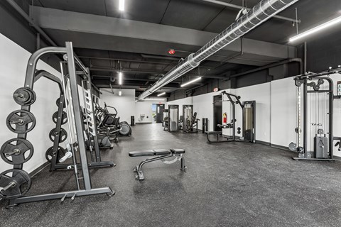 A black and white photo of a gym with various exercise equipment.