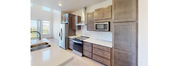 A kitchen with a white counter top and wooden cabinets.
