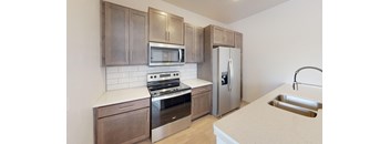 A kitchen with a stove, oven, microwave, and refrigerator.