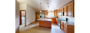A kitchen with wooden cabinets and a large island.
