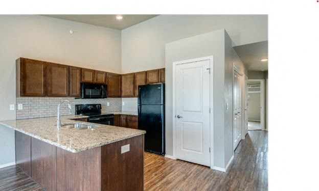 Kitchen with Granite Countertops, Black Appliances and Breakfast Bar