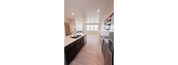 A kitchen with dark wood cabinets and stainless steel appliances.