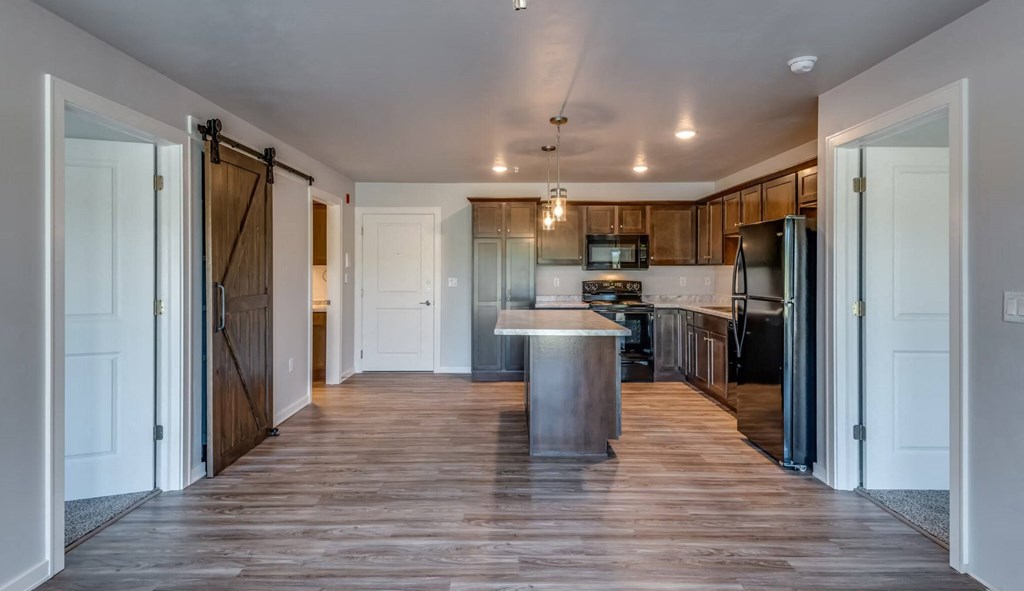a kitchen with a center island and a stainless steel refrigerator