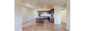A kitchen with a wooden floor and white walls.