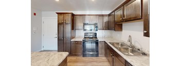 A kitchen with wooden cabinets and a stainless steel sink.
