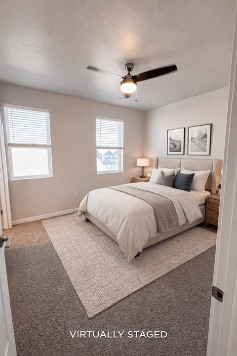 A bedroom with a bed, two lamps, and two pictures on the wall.