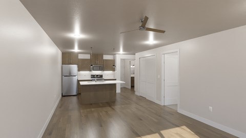 an empty living room and kitchen with white walls and wood floors