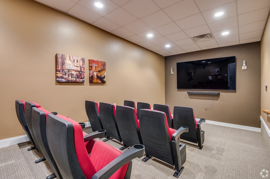 A room with a row of chairs and a television mounted on the wall.