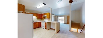 A kitchen with a white refrigerator and wooden cabinets.