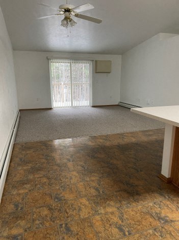 an empty living room with a ceiling fan