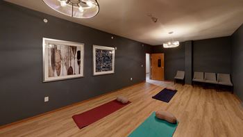 a yoga room with three yoga mats on the floor and three pictures on the wall