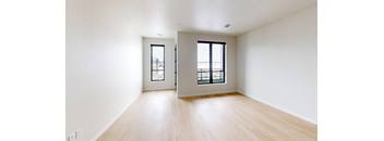 A room with wooden floors and two windows.