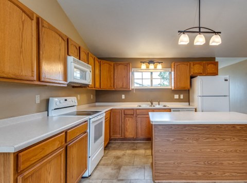 a kitchen with white appliances and wooden cabinets