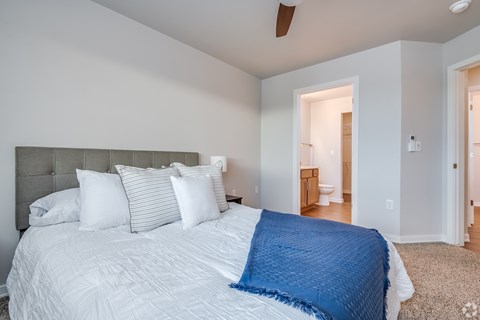 A bedroom with a large bed and a ceiling fan.