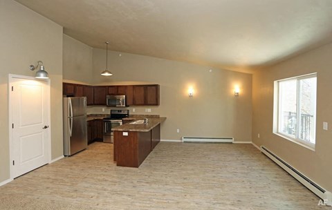 A kitchen with a refrigerator, microwave, and oven is shown in this image.
