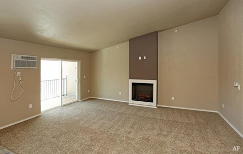 A spacious living room with a fireplace and sliding glass doors.