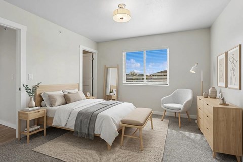 A bedroom with a bed, chair, and dresser.