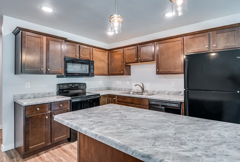 a kitchen with a marble counter top and black appliances