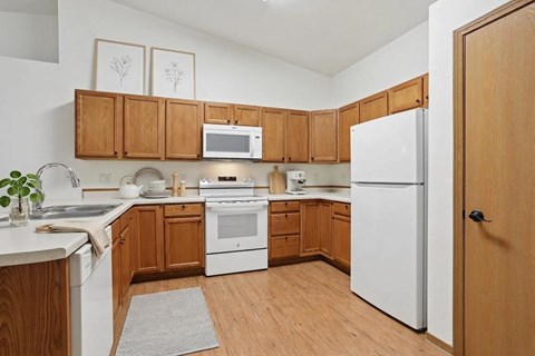 A kitchen with wooden cabinets and white appliances.