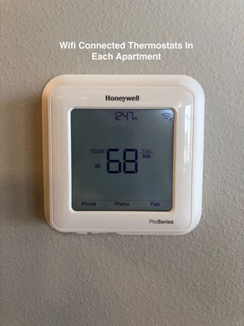 a thermostat on a wall with the words wifi connected thermostats in each apartment