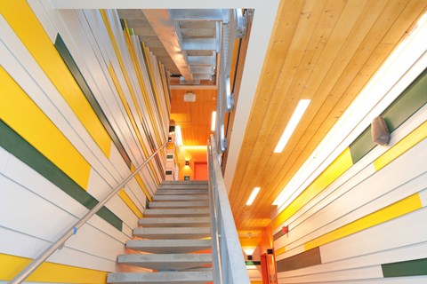 A staircase with a yellow and green striped wall.