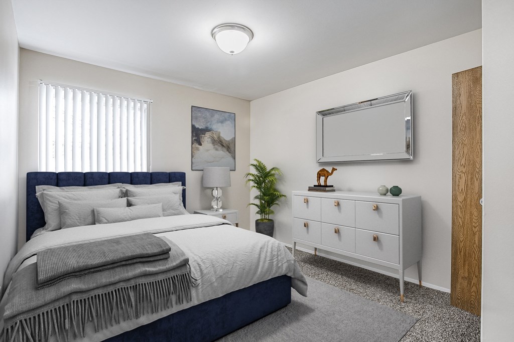 a bedroom with a bed and a dresser with a mirror