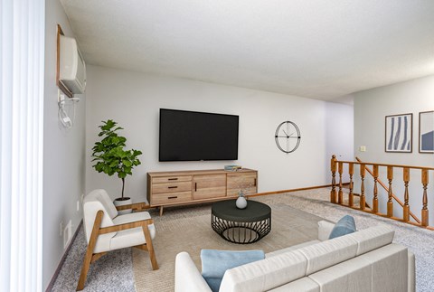 a living room with white walls and a large tv on the wall