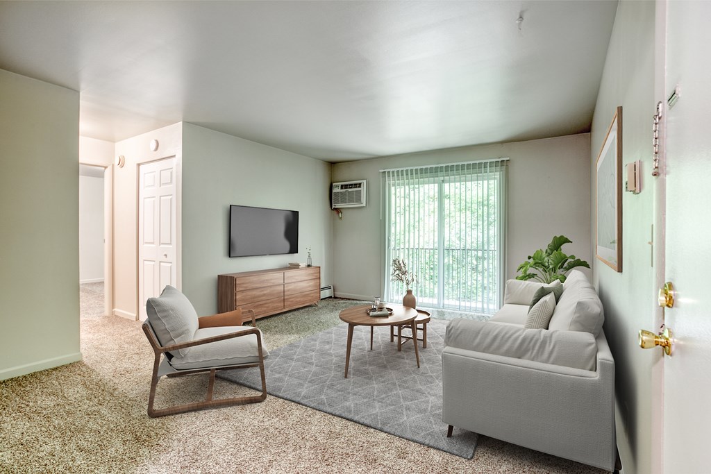 A living room with a grey couch, a wooden chair, and a television.