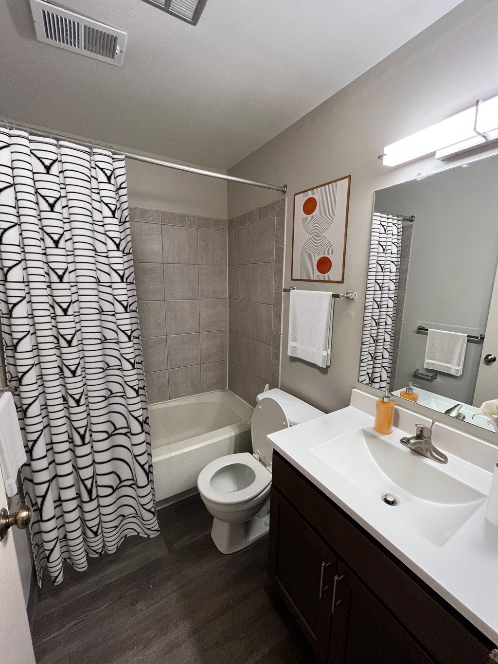 A bathroom with a toilet, sink, and shower.