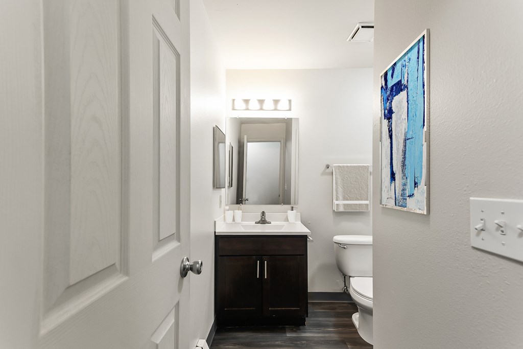 A bathroom with a white sink and a white toilet.