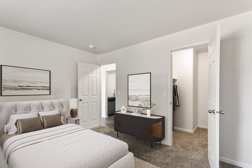 A bedroom with a large bed and a painting on the wall.