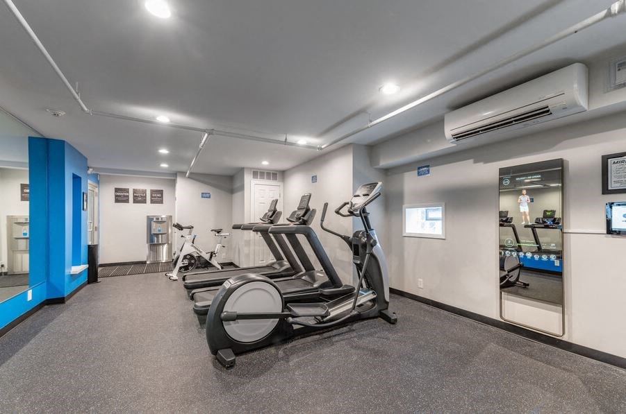 a gym with cardio machines and weights in a building