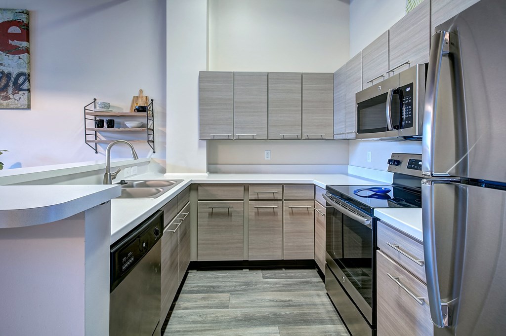A modern kitchen with stainless steel appliances and wooden cabinets.