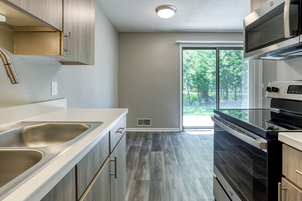 a kitchen with white countertops and stainless steel appliances
