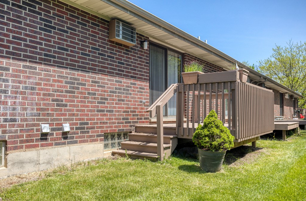 a deck in front of a brick building