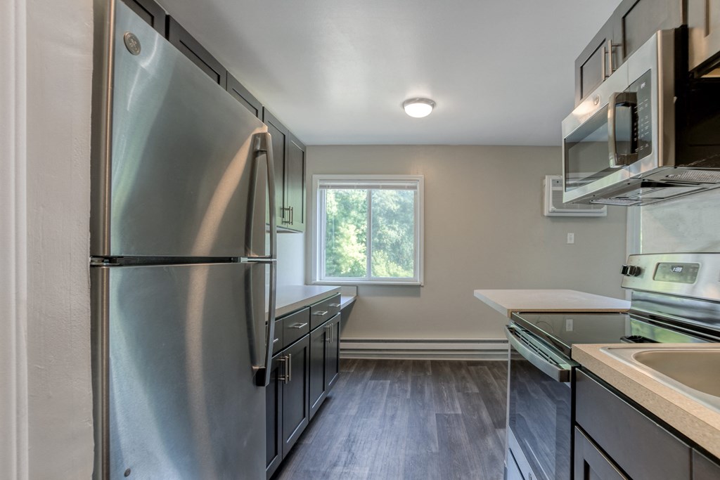 a kitchen with stainless steel appliances and brown cabinets