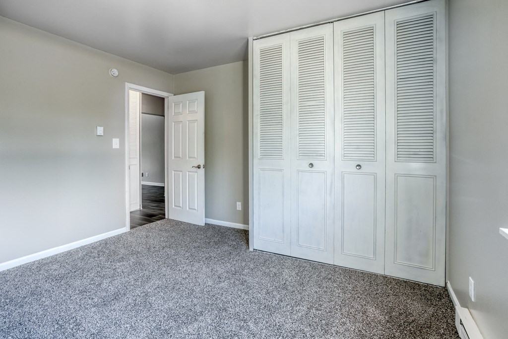a bedroom with a closet and a door to a bathroom