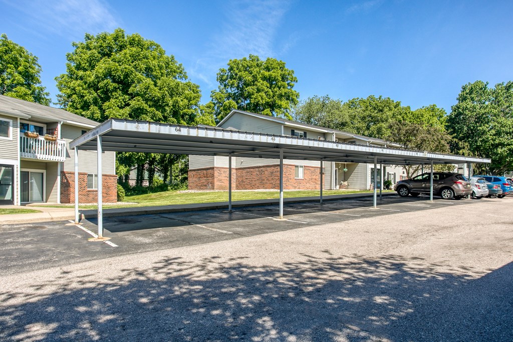 A parking lot with a building and cars parked in front.