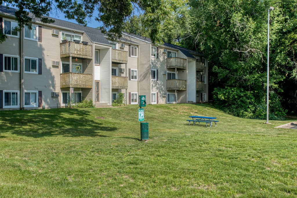 Green Space with Pet Stations a grassy area with a picnic table in front of an apartment building