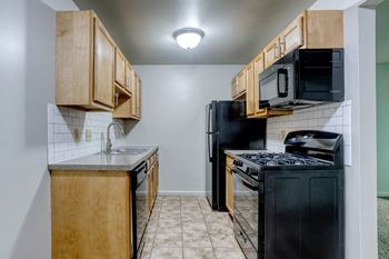 a kitchen with wood cabinets and black appliances